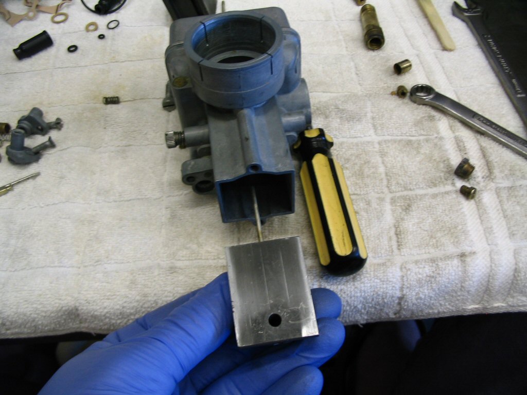 Insert the slide complete with tapered needle into the body of the carburetor. Notice that the large flat area of the slide must face the intake manifold, not the air filter.