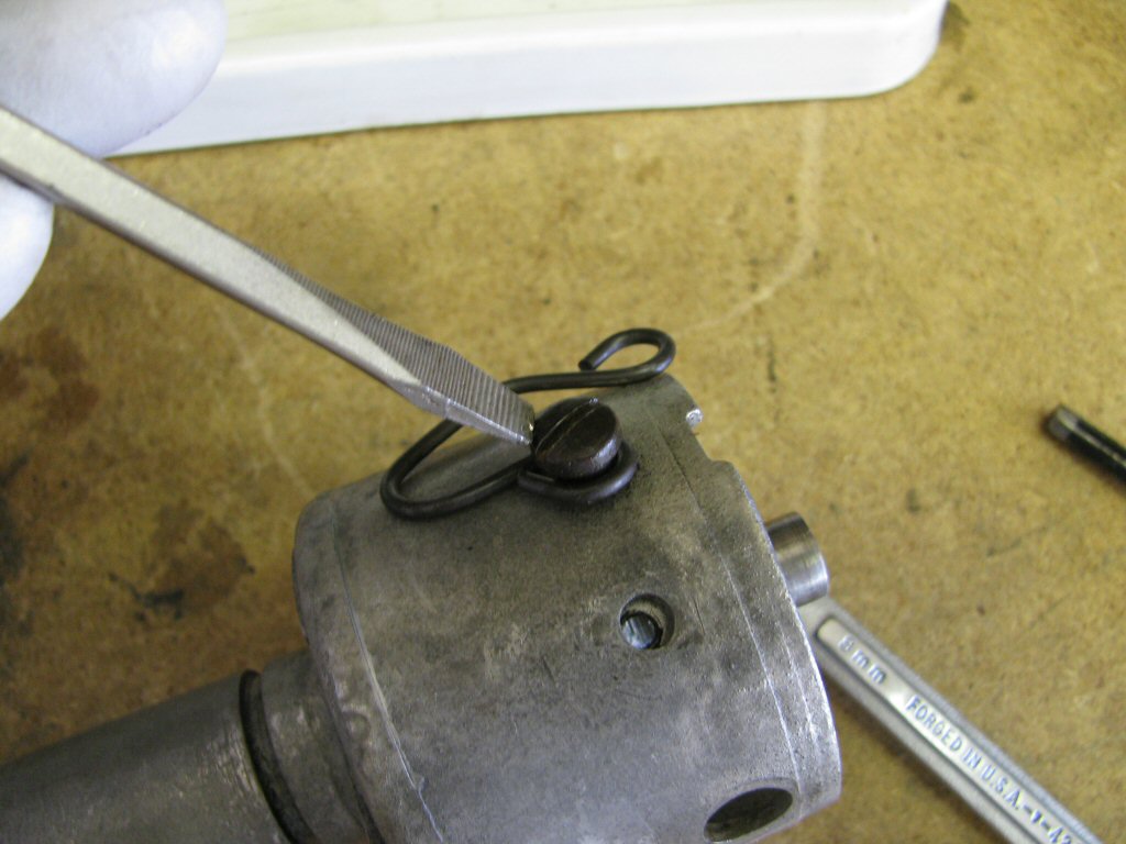 Remove the shoulder bolt and the spring clip that holds the distributor cap in place.