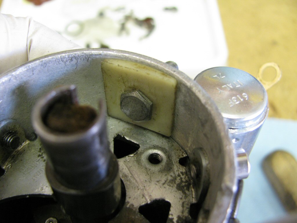 Fit the bolt and inner plastic insulation piece through the side of the distributor body.