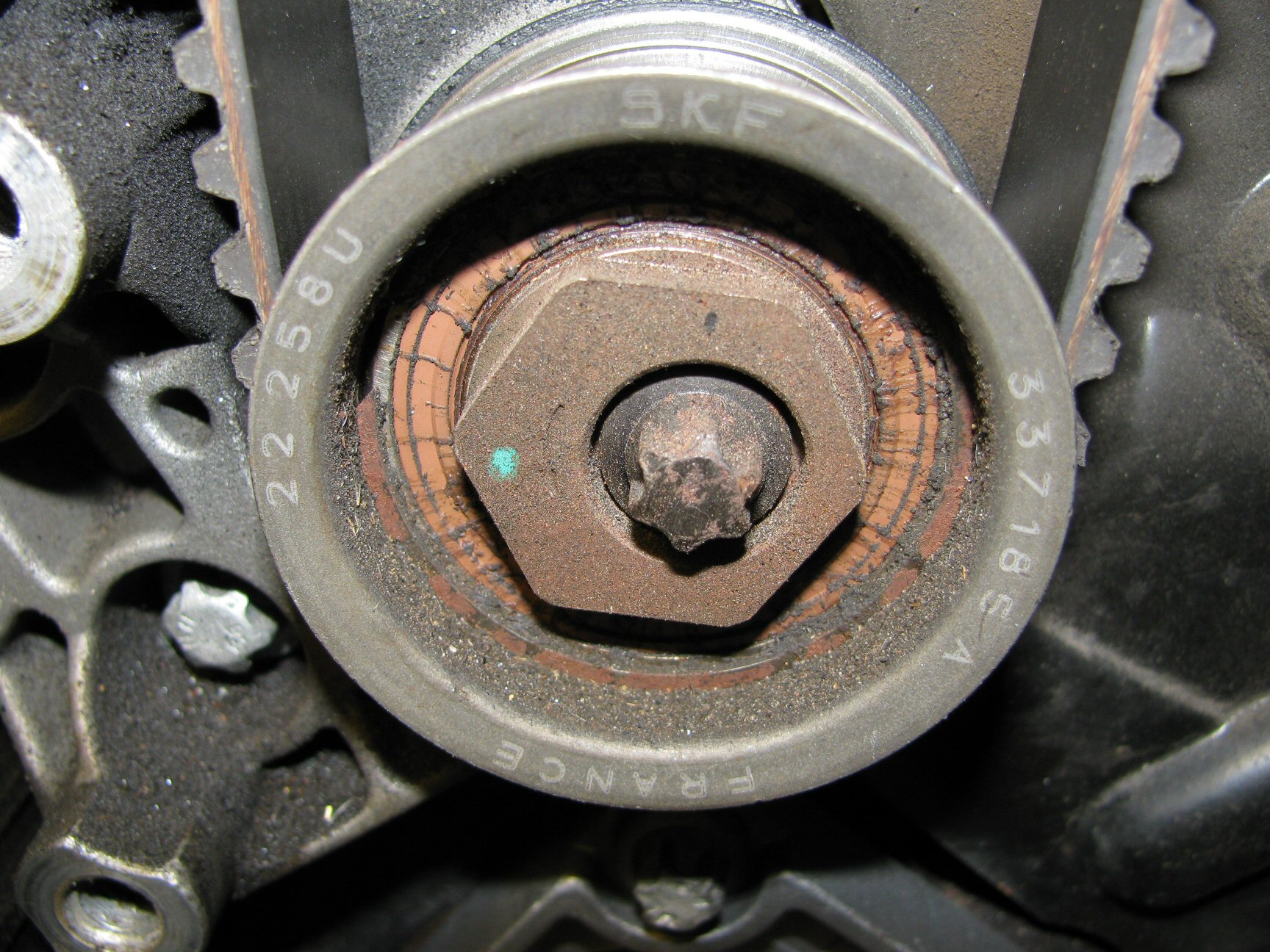 Upper idler pulley. Note the location of the green dot indicating a good initial position of 9 o'clock.