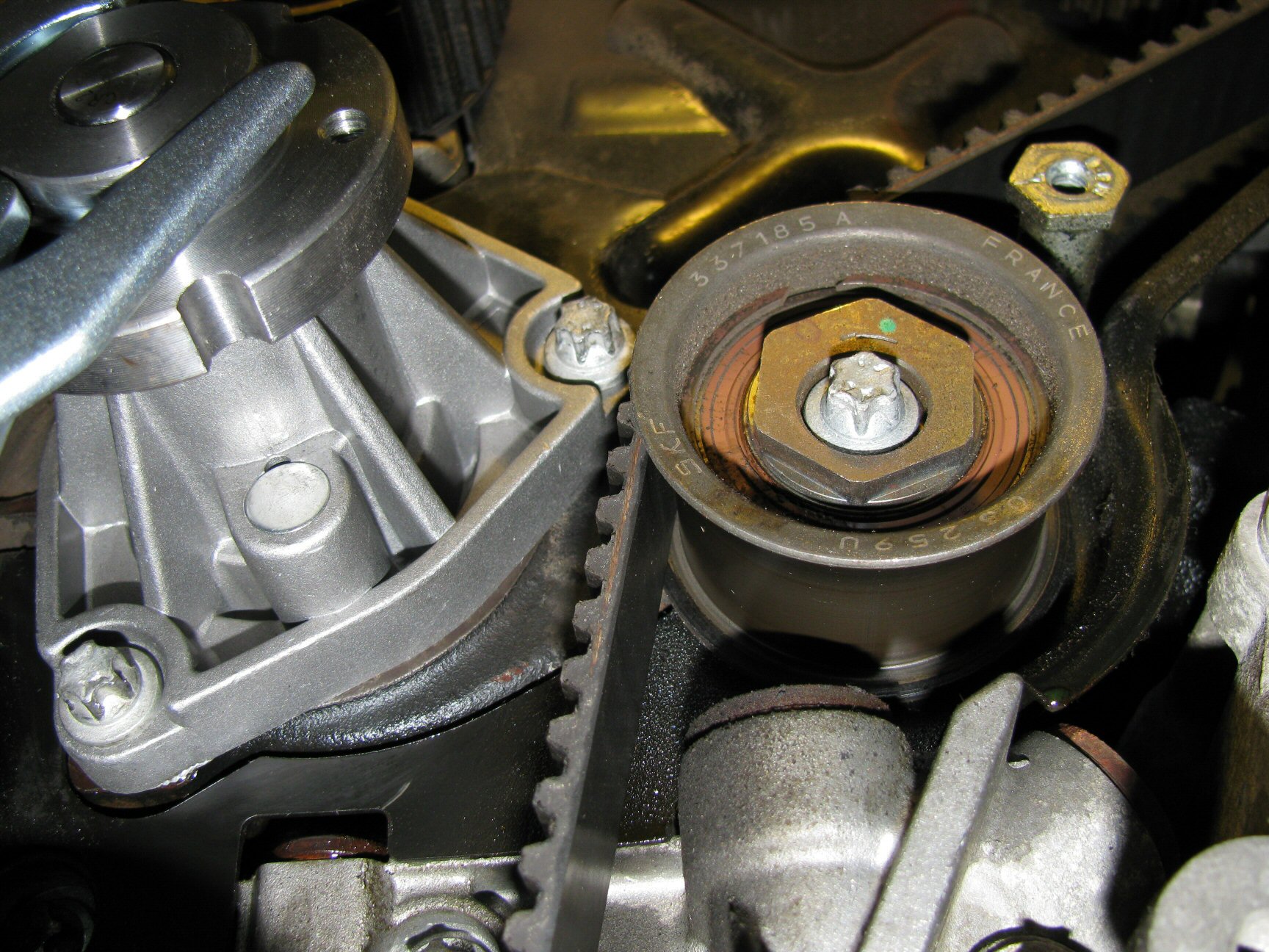 Lower idler pulley. Note the location of the green dot indicating a good initial position of 12 o'clock.