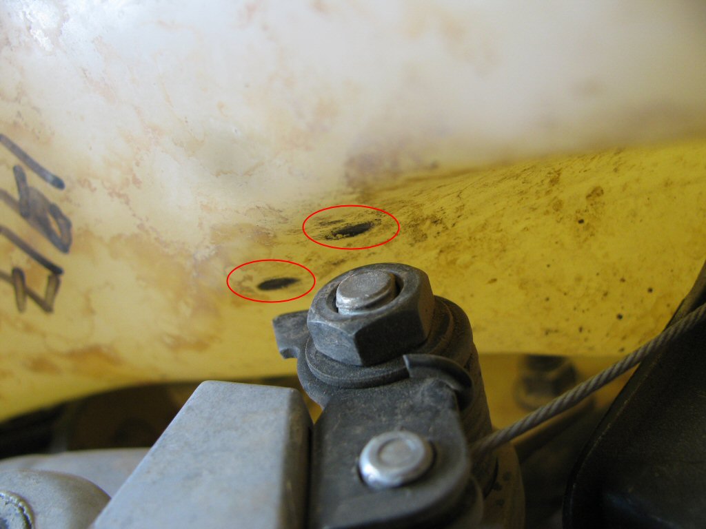 Clarke tank on my 1993 Suzuki DR350. The circles indicate that the tank was rubbing on the nut and stop arm of the decompression lever assembly.