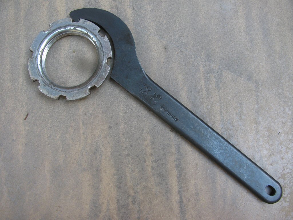 Fixed hook spanner wrench to adjust the shock preload on a Suzuki DR350.