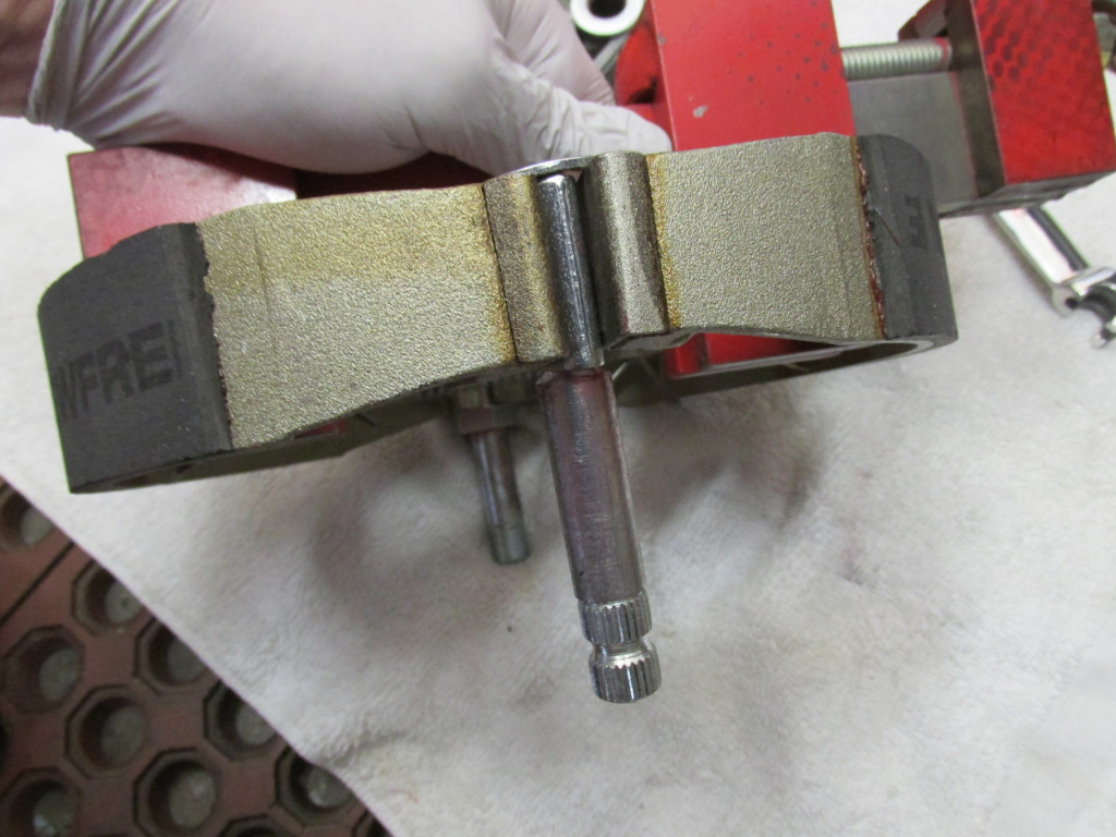 This is the rear pivot. It rotates within the brake plate. Apply a light coating of grease both to the portion that fits between the brake shoes AND the shaft that rotates within the rear brake plate.