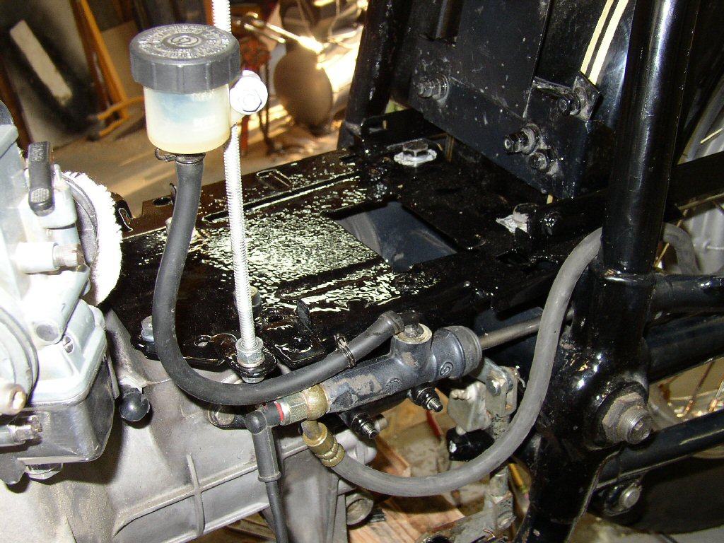 There is a rod sticking up from the tray to hold the brake fluid reservoir and the brake line runs back to the stock T-3 setup.