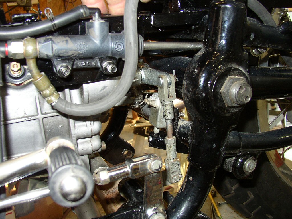 The brake push rod is a close fit but clears the transmission linkage by a good half inch and runs between the top of the swing arm and the frame member. With the starter in place the neighborhood will be a little crowded but I don't foresee any problems.