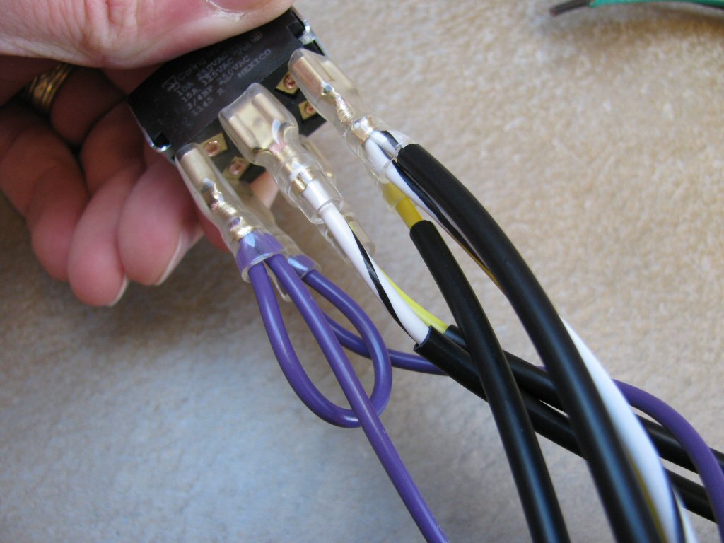 The white/black and yellow/black wires from the turn signal switch are connected to the two terminals on the opposite end of purple wires on toggle switch. Note how the white/black wires are on the same side.
