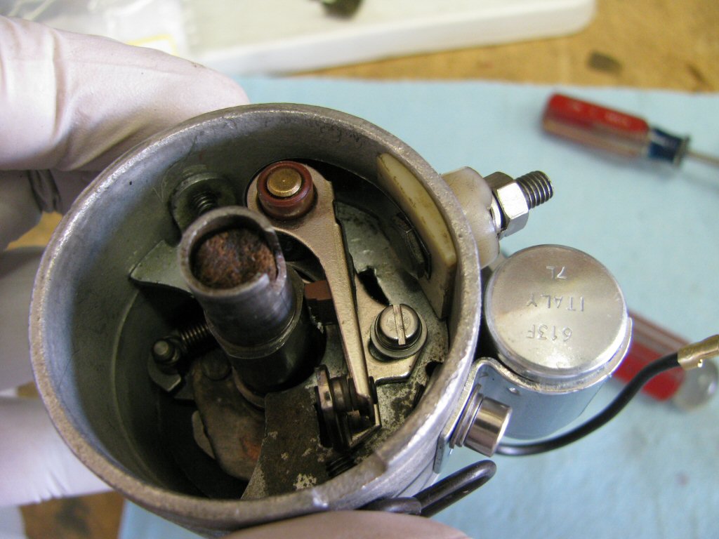 Fit the arm of the contact breaker as shown. Note how the metal tab fits under the head of the bolt.