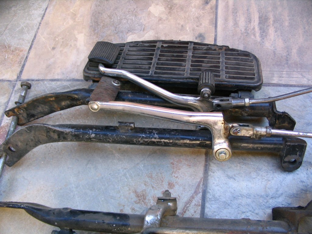A side-by-side comparison of the brake side. The earlier set is nearer the camera. Notice the overall shape of the rail is a bit different. Note also the brake pedals are different. I think the original pedal on the earlier set was cut off and this replacement welded in place. The heal rest on the earlier set was also cut off and the pivot welded on lower. In other words, the early brake pedal has been butchered pretty severely...for reasons unknown. While I don't think the early and later brake pedals were 100% identical, this early version is in poor shape.