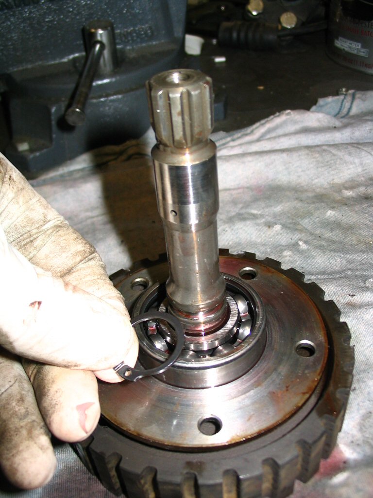 Remove the snap ring (MG# 90271020) from the shaft. This snap ring keeps the bearing in place.