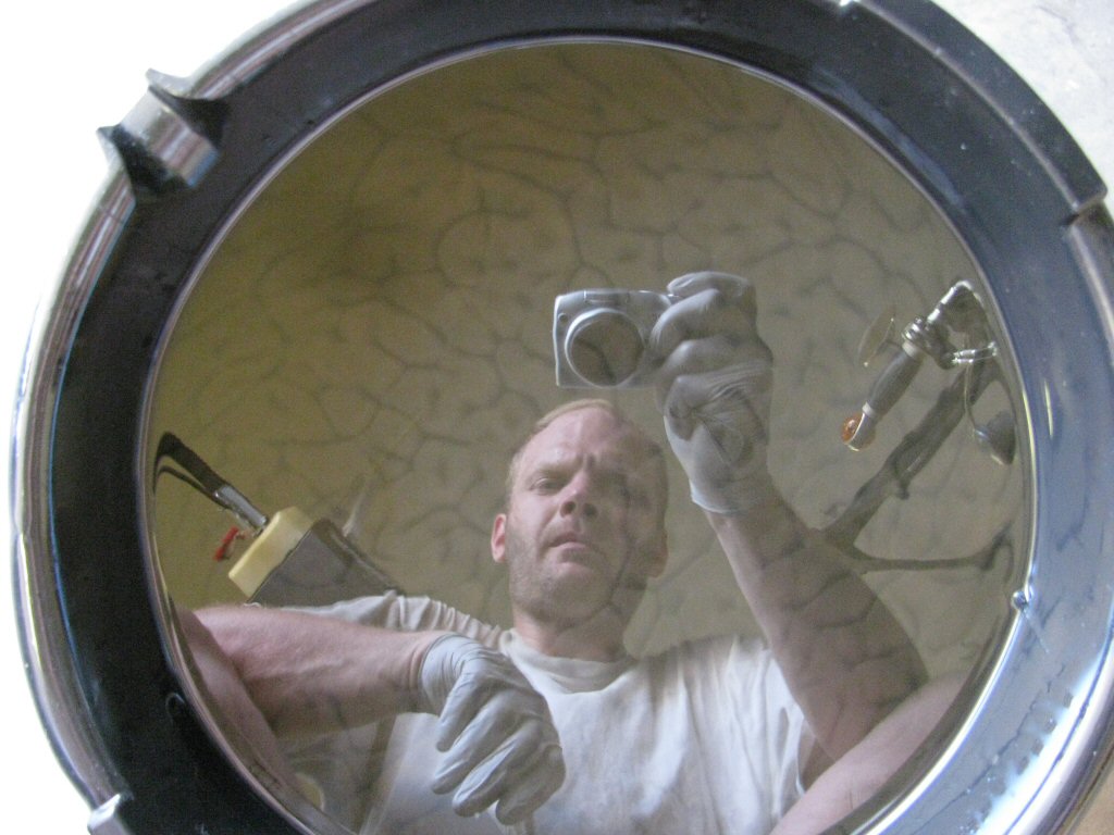 Reflections in the pool of freshly drained oil...note the trails left by the assembly lube that has washed out. Gregory concentrates to make sure the camera angle is okay.