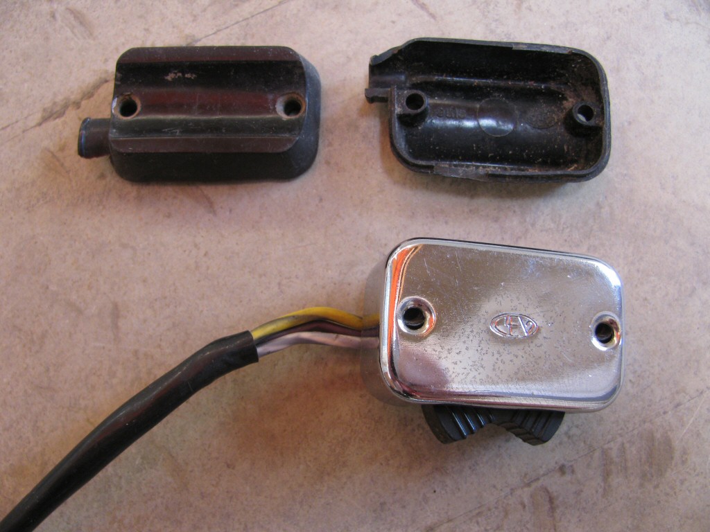 Right handlebar switch for actuating the turn signals (MG# 12750301). Also shown is both sides of the plastic piece that fits between the switch and the brake lever perch.