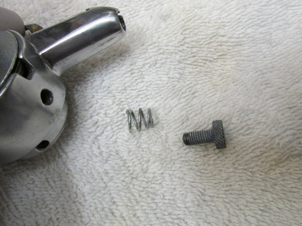 This is the thumb screw and spring that will press against the rub block. The spring is cone shaped. The smaller diameter end should fit against the head of the thumb screw.