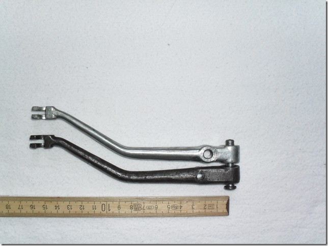 This picture shows the later version (above) and the earlier on the same pivot bolt. You can see clearly the all-in-all length is identical but the SECTIONS are different. The earlier lever is taken from my 1968 V700 gearbox.